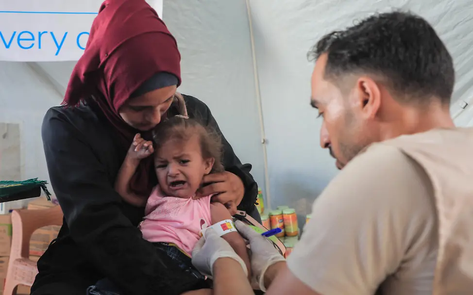 Ein unterernährtes Kind in Gaza wird von einem Gesundheitsmitarbeiter gemessen. Die Menschen benötigen dringend Hilfsgüter.