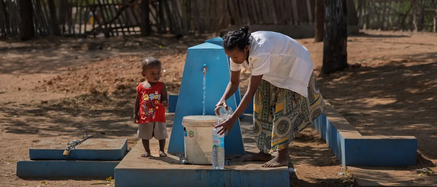 Madagaskar: Eine Mutter und ihr Kind nutzen einen Brunnen.