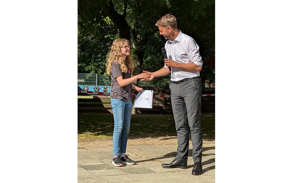 Tiana bei der Überreichung der Teilnahmeurkunde am Kinderbeirat durch Oberbürgermeister Dennis Weilmann.
