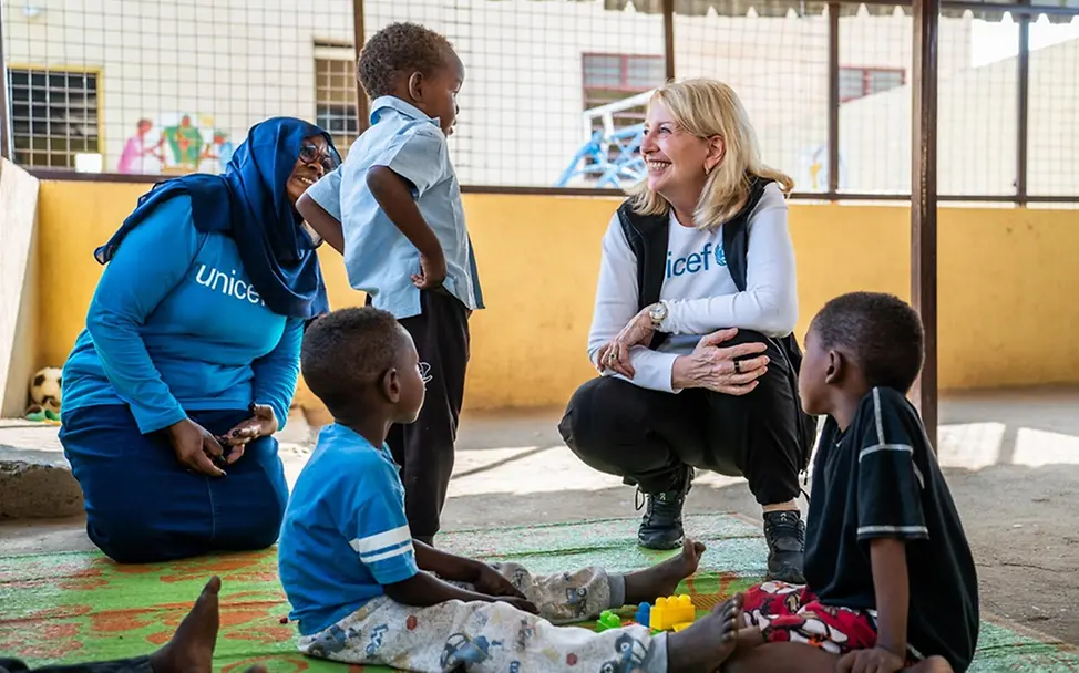 UNICEF-Exekutivdirektorin Catherine Russell unterhält sich mit dem vierjährigen Ahmed auf dem Spielplatz eines Kinderzentrums.