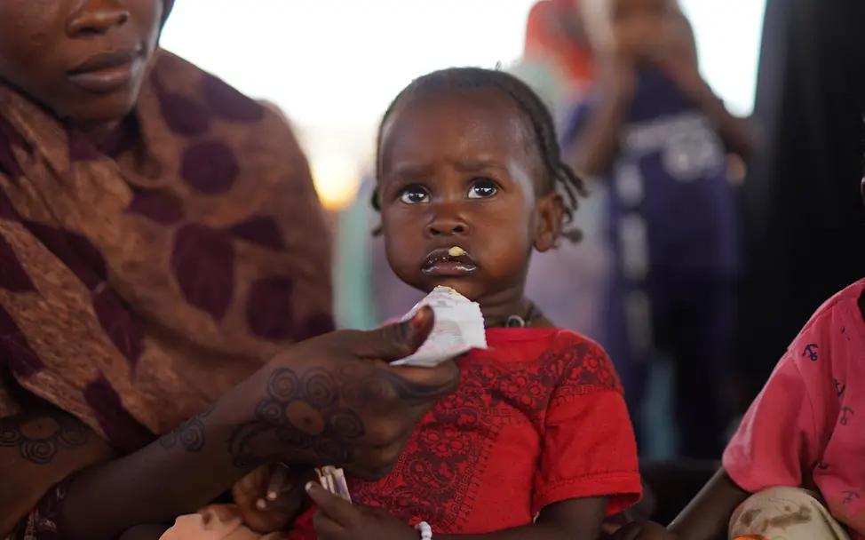 Wohltätige Geschenke: Ihre Spende hilft UNICEF, mangelernährte Kinder mit therapeutischer Nahrung zu versorgen. | © UNICEF/Jamal Originelle Geschenkideen für den guten Zweck: Eine Mutter füttert ihr Kind mit Erdnusspaste.