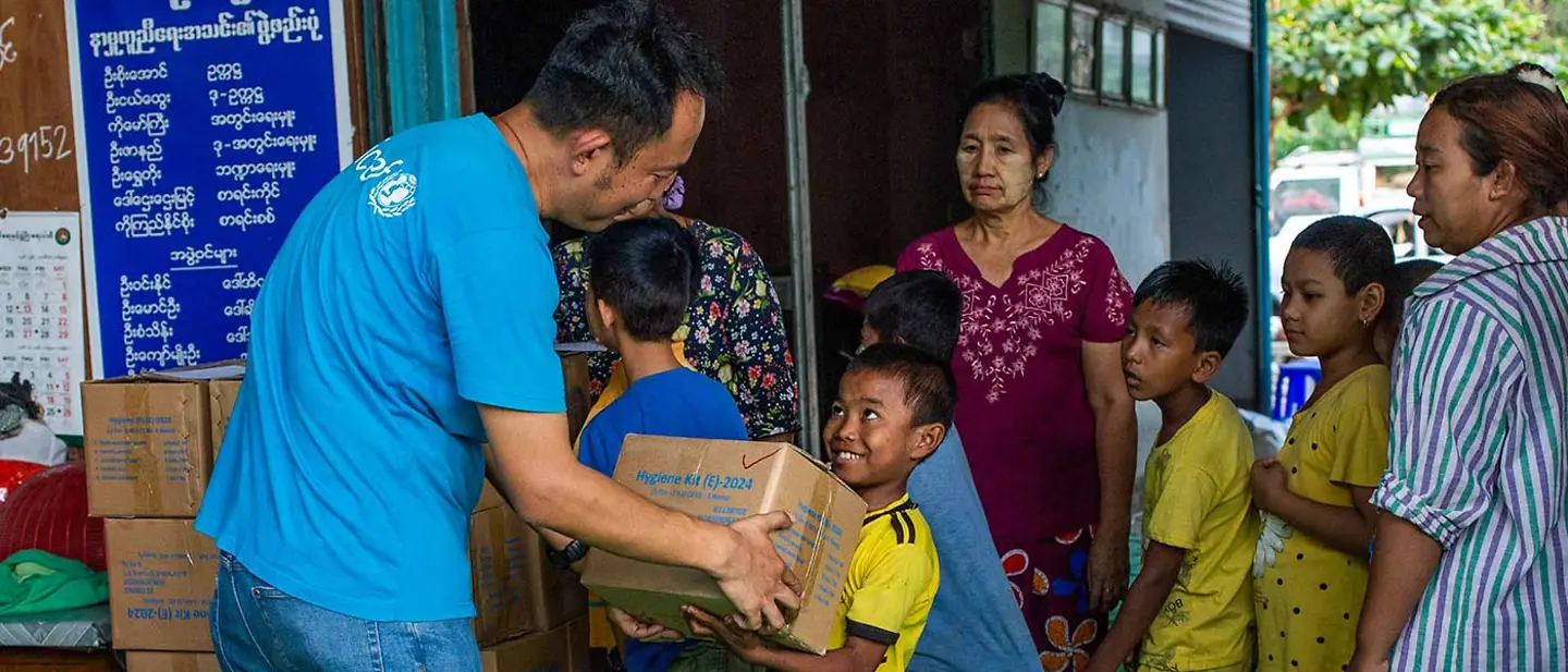 Spenden Nothilfe: Ein UNICEF-Mitarbeiter übergibt nach einem Erdbeben in Südostasien ein Hygieneset an einen Jungen
