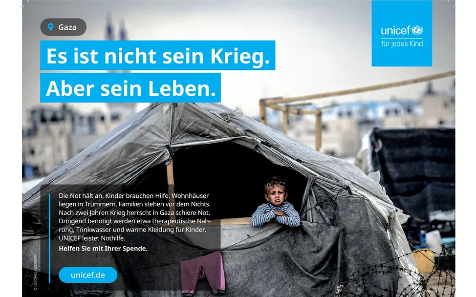Junge sitzt in einem Zelt.