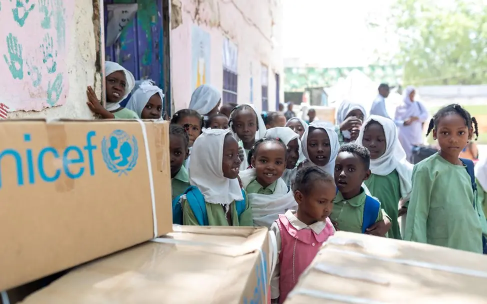 Kinder einer Schulklasse freuen sich: Endlich bekommen sie Lernmaterialien. | © UNICEF/Dawod UNICEF Impact Circle: Hilfsgüter erreichen Schule.