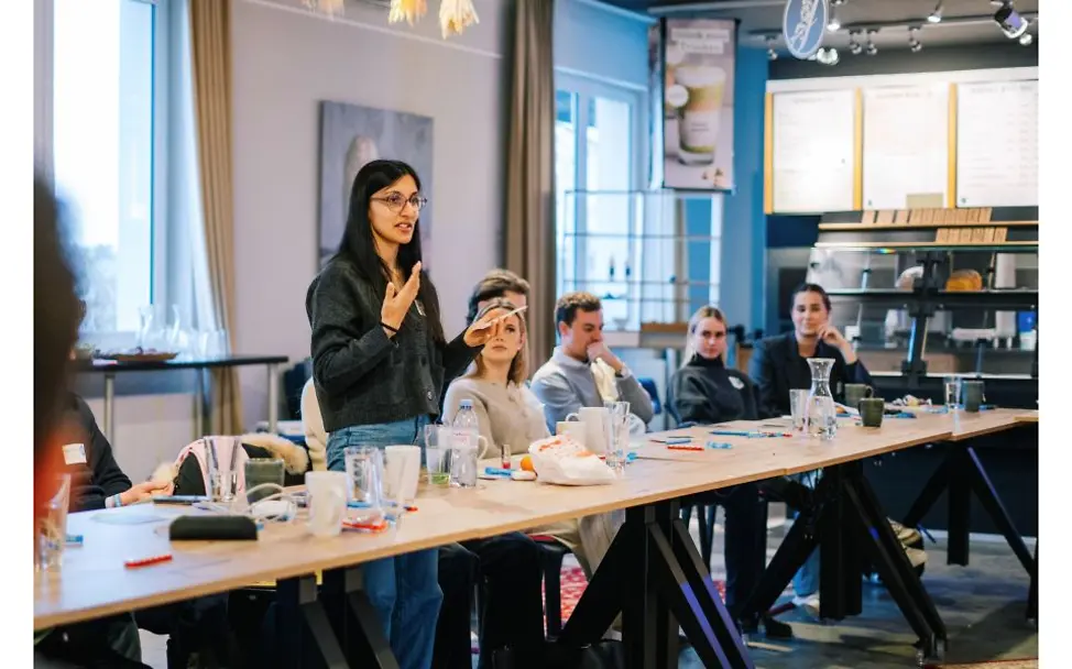 Mitglieder:innen der NextGens sitzen an einem Konferenztisch.