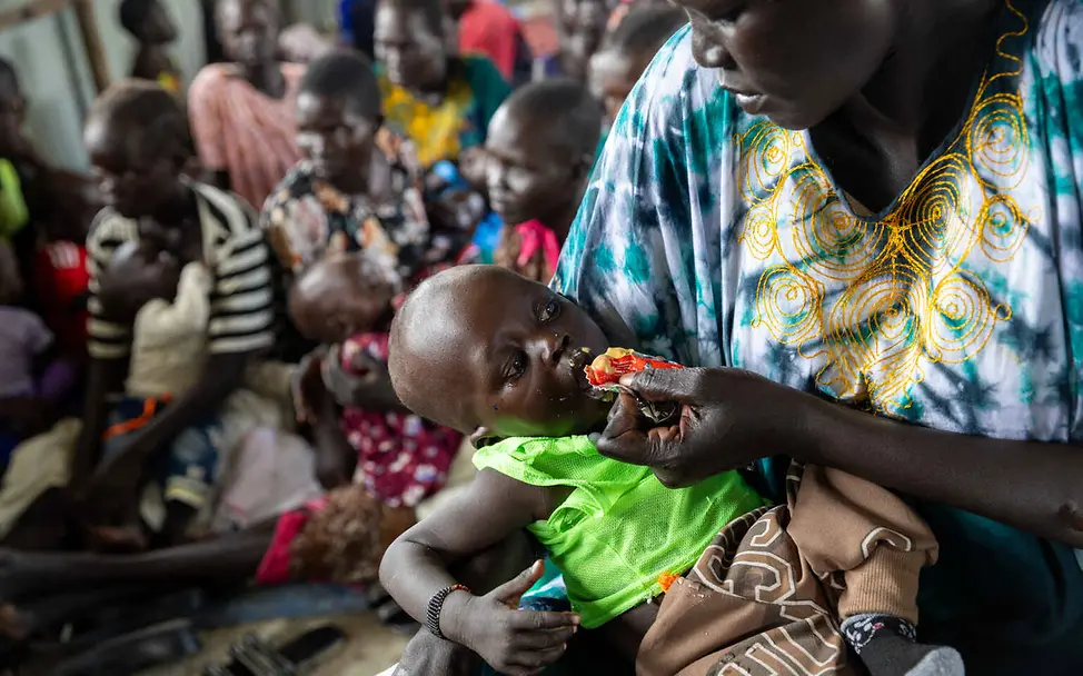 Südsudan Hungerkrise: Eine Mutter füttert ihr Kleinkind mit Erdnusspaste.