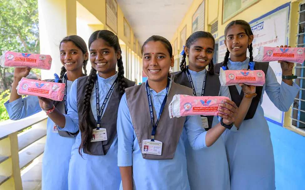 Periodenarmut: UNICEF verteilt Menstruationsprodukte, damit Mädchen weiter zur Schule gehen können. | © UNICEF Was ist Periodenarmut: Schülerinnen posieren mit Binden in ihrer Schule.