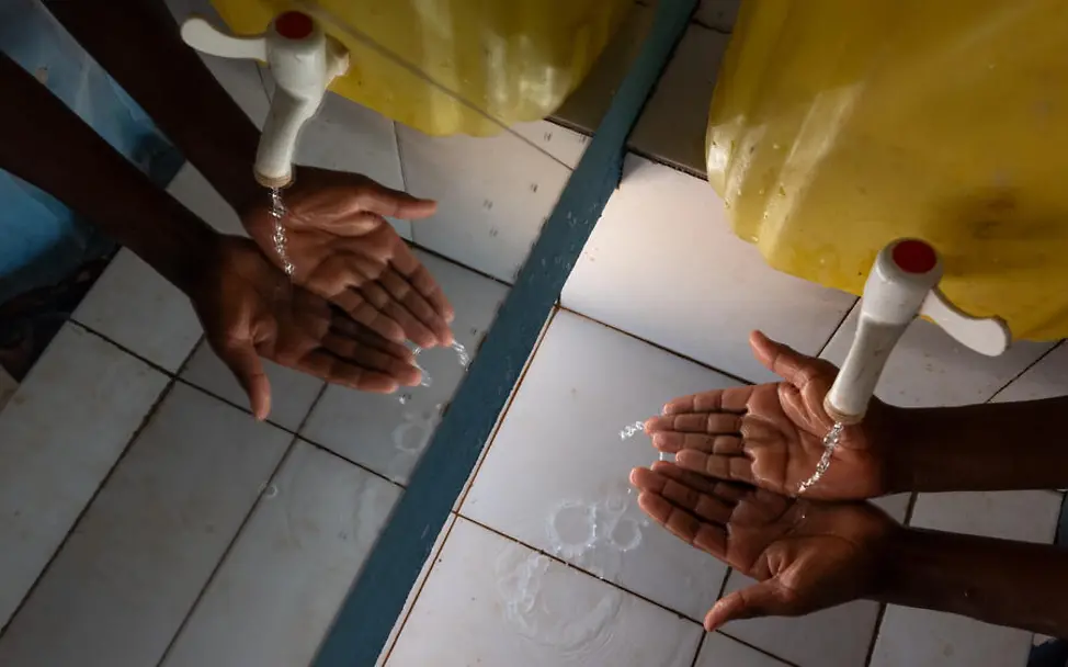 Periodenarmut: Alle Kinder sollten sauberes Wasser zum Trinken und Waschen haben. | © UNICEF/Andrianantenaina Was ist Periodenarmut: Zwei Hände, die sich die an einem Wasserkanister waschen.