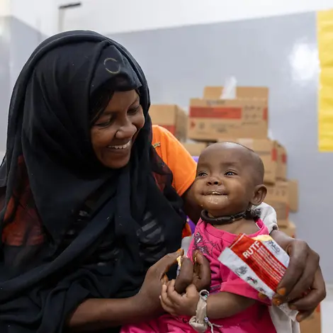 Hadiga mit ihrer Tochter. | © UNICEF/UNI886247/Dawod Mutter füttert Kind auf ihrem Schoß