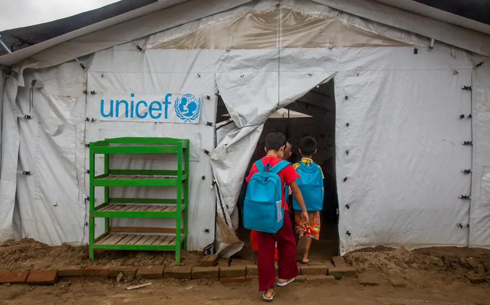 Erdbeben einfach erklärt: Kinder gehen zum Unterricht in ein von UNICEF errichtetes Schulzelt. 