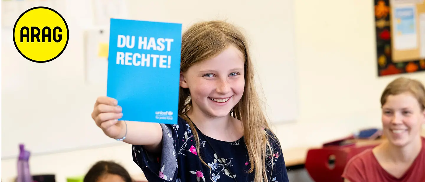 Ein Kind hält ein "Du hast Rechte" Büchlein hoch