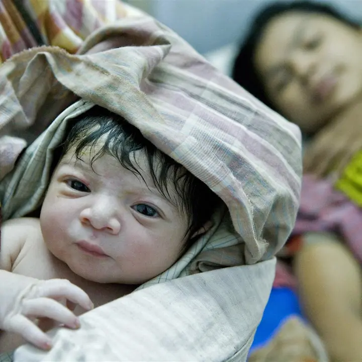Ein Neugeborenes in Bangladesch auf dem Arm einer Geburtshelferin | © UNICEF/Noorani 80 Jahre UNICEF Jubiläum: Ein Neugeborenes in Bangladesch. UNICEF setzt alles daran, Kindersterblichkeit zu verringern.