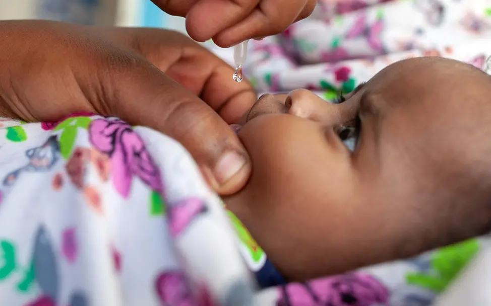 In Somalia erhält ein kleines Mädchen eine Polio-Impfung. | © UNICEF/Naftalin UNICEF 80 Jahre Fotos: In Somalia erhält ein kleines Mädchen eine Polio-Impfung.