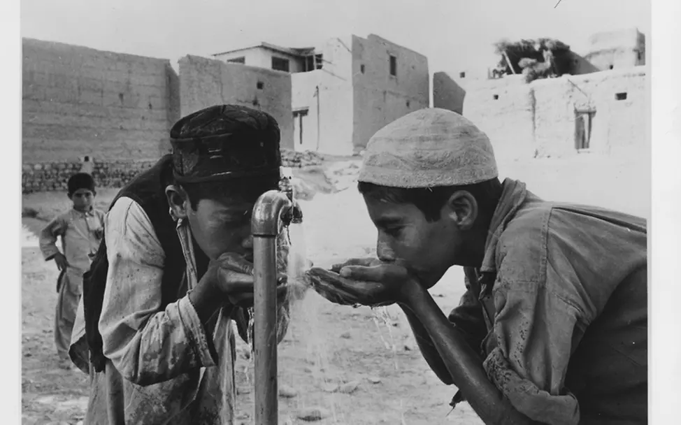 Jungen stillen ihren Durst an einem heißen Tag in Afghanistan, 1976. | © UNICEF/Satyan UNICEF 80 Jahre Fotos: Jungen stillen ihren Durst an einem heißen Tag in Afghanistan, 1976.