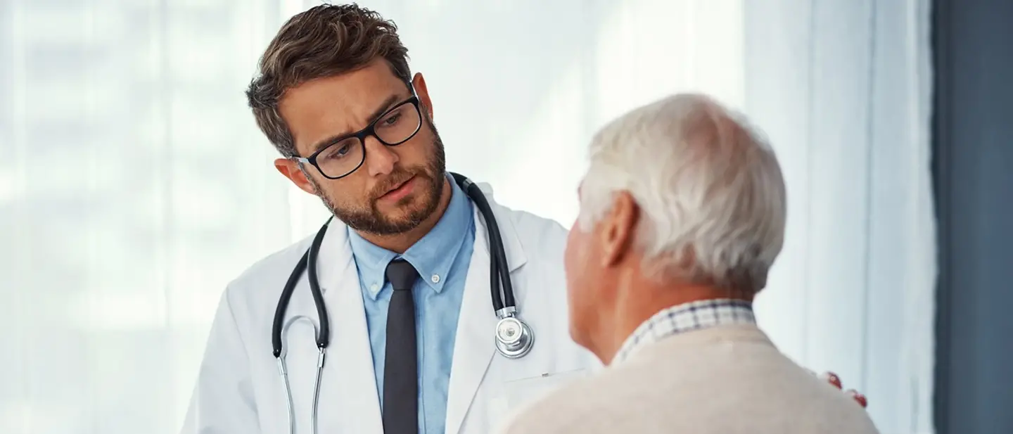Mit einer Patientenverfügung stellen Sie sicher, dass Ihre medizinische Behandlung Ihren Wünschen entspricht. Ein Arzt spricht mit einem älteren Patienten.