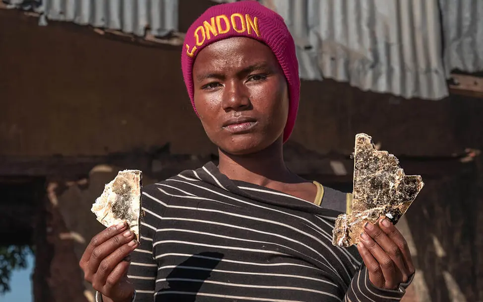 Kinderarbeit weltweit: Eine Jugendliche verkauft Feuerholz auf einem Markt in Madagaskar, um Geld zu verdienen