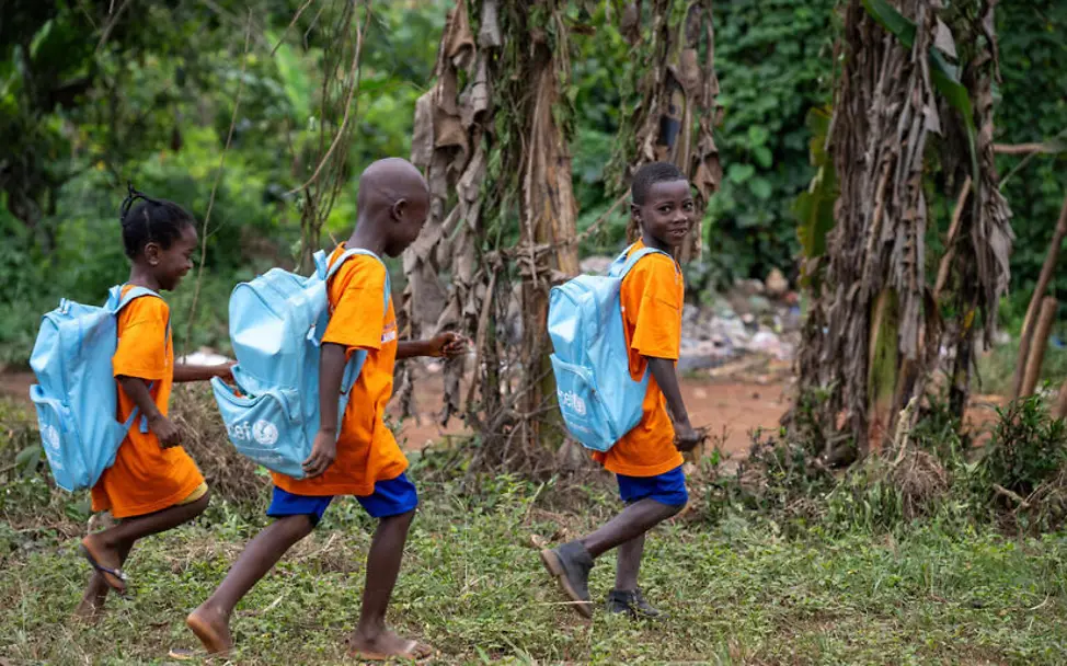 Mobile Schulen ermöglichen auch Kindern in abgelegenen Gebieten eine Schulbildung. | © UNICEF/Dejongh Kinderarbeit einfach erklärt: Drei Kinder mit UNICEF-Schulrucksäcken auf dem Weg zur Schule.