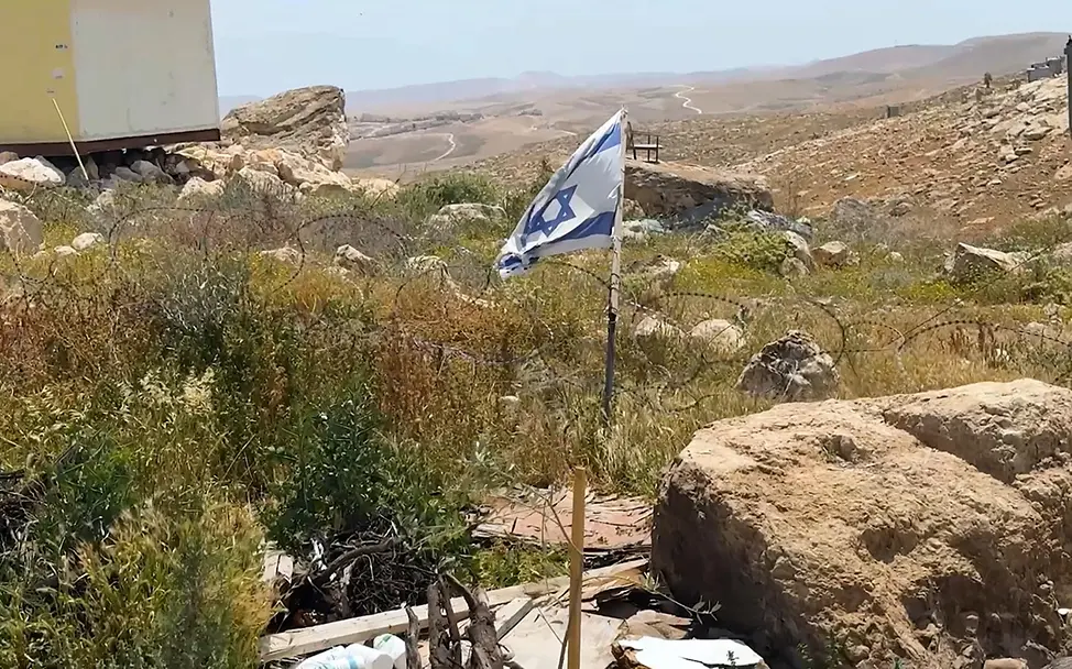 Eine israelische Flagge und Stacheldrähte in Hebron | © UNICEF/SoP/2026 Aufwachsen im Westjordanland: Eine israelische Flagge und Stacheldrähte in Hebron