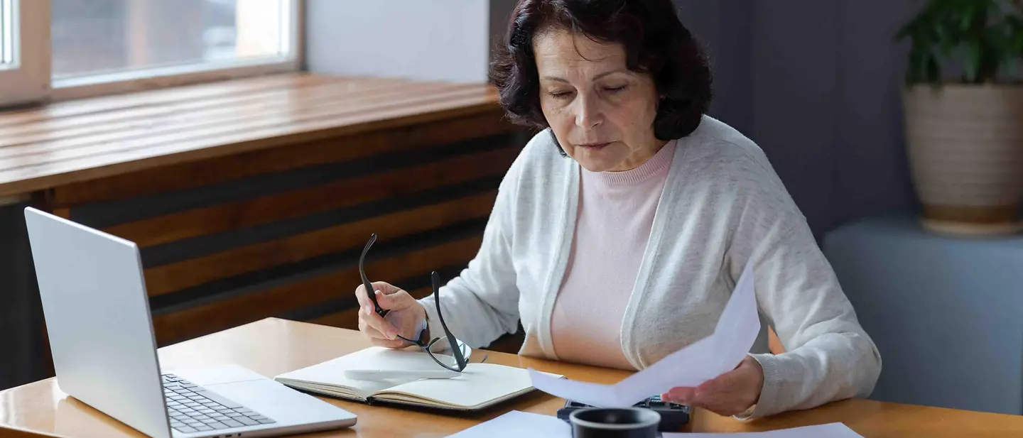 Checkliste Todesfall: Eine Frau macht sich am Schreibtisch Notizen