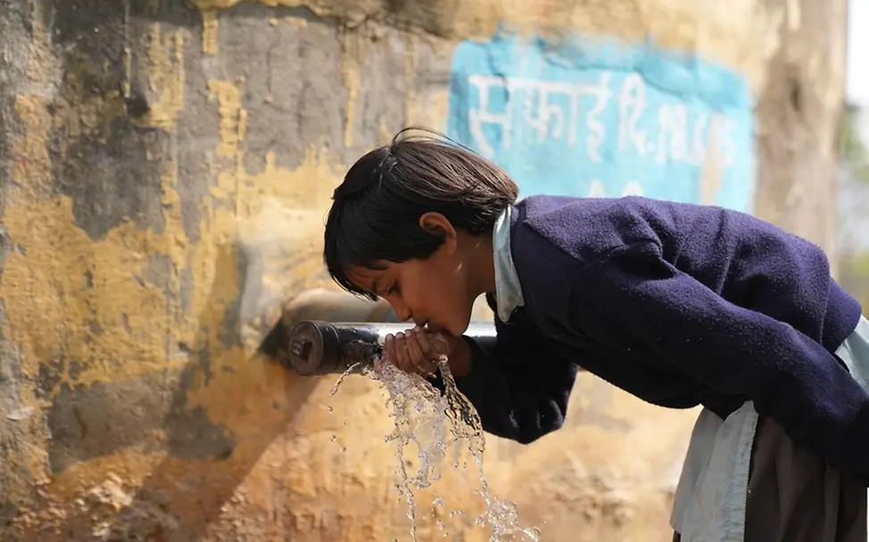 Sara trinkt von einem Wasserhahn an ihrer Schule in Indien. | © UNICEF/Misra Dürre: Folgen für Kinder & Ursachen: Sara trinkt von einem Wasserhahn an ihrer Schule in Indien.