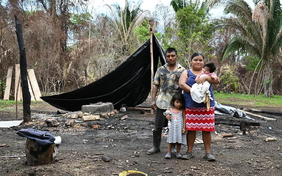 Waldbrände Folgen: Eine Familie mit zwei kleinen Kindern steht vor einem provisorischen Zelt.