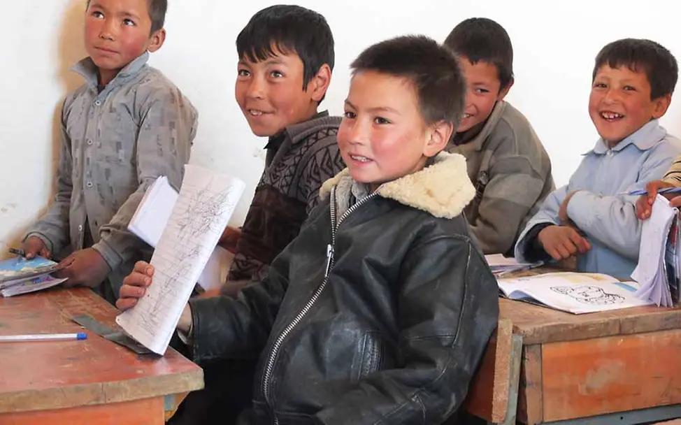 Afghanistan: Jungen in einer Schulklasse zeigen stolz, was sie geschrieben haben.