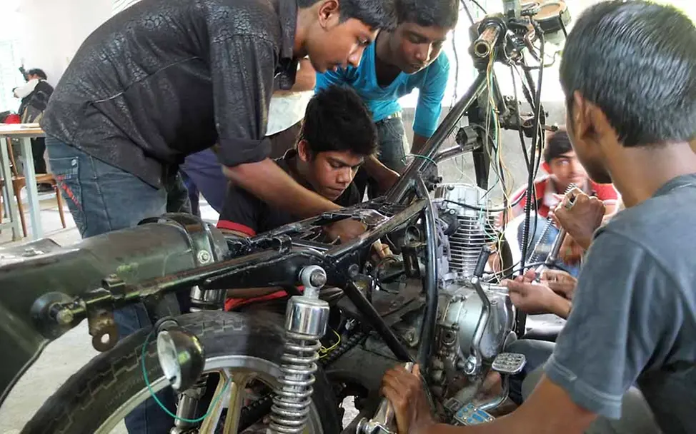 UNICEF unterstützt Jugendliche in Bangladesch bei der Berufsfindung. | © UNICEF/UNI261074/ Ausbildungen für Jugendliche in Bangladesch: Jugendliche schrauben an einem Motorrad.